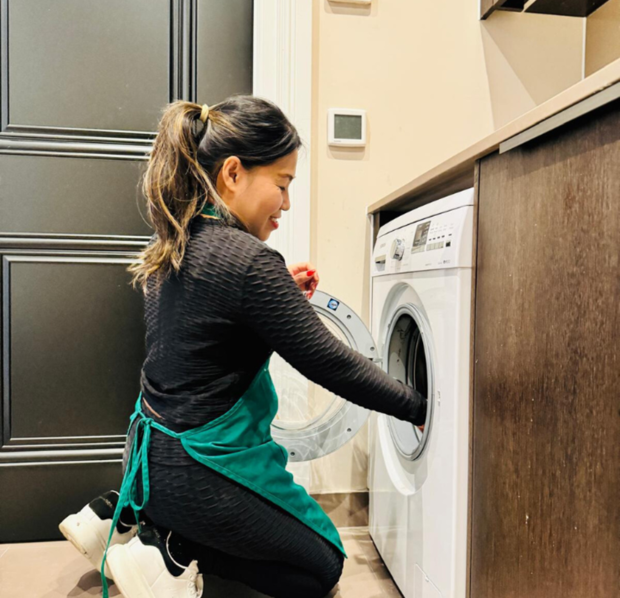 Fillipino Housekeeper loading washing machine Fillipino Housekeeper loading washing machine
