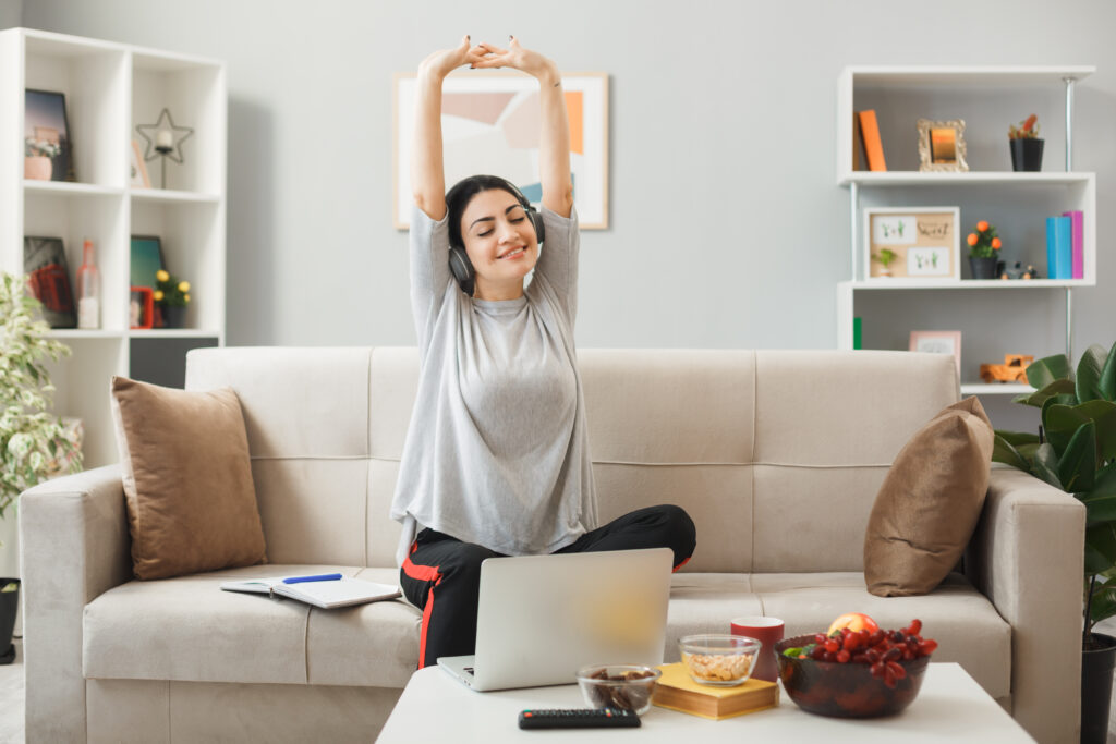 Woman looking happy stretching and listening to music