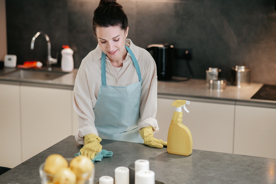 Young dark-haired woman doing housework using natural cleaning recipes
