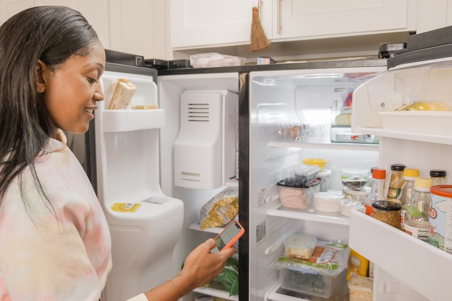 Woman opens her fridge organization in a kitchen