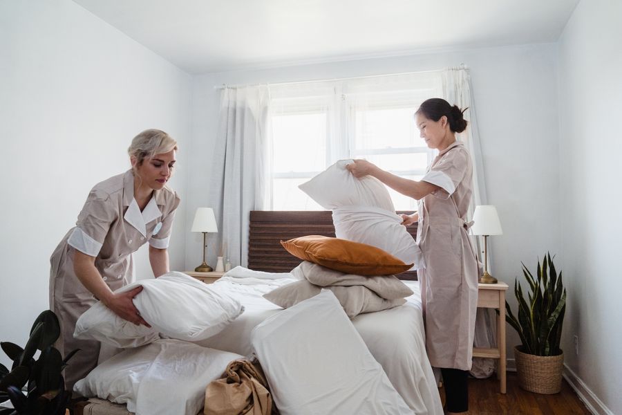 professional housekeepers tidying the bed after laundry